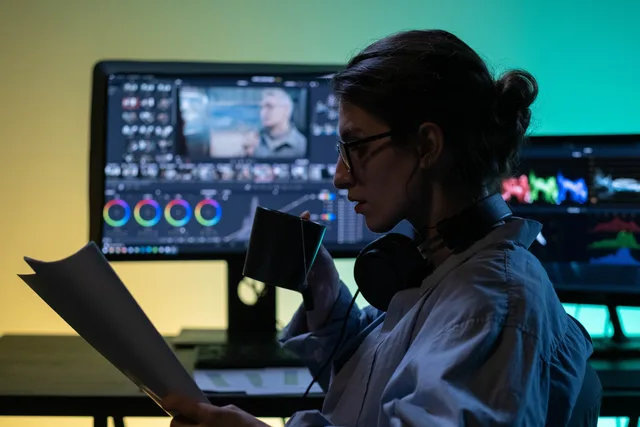 A concentrated editor sipping tea while reviewing papers in a modern editing studio. How to set AI content operations service standards with a scoring rubric