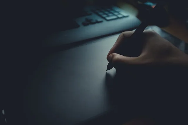 pen, writing, hand, dark, office, laptop, blue office, blue laptop, blue writing. How to Build an AI Content Repurposing Workflow for UK SMEs
